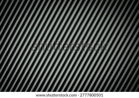 Dark grey ribbed surface with diagonal lines creating a rhythmic pattern.