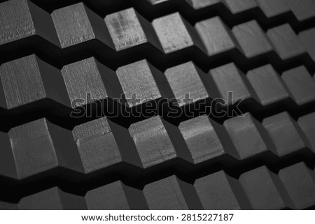 Dark grey steps Background abstract pattern texture design monochrome close up shot of a highly structured, geometric surface composed of repeating block like ridges.pattern features alternating raised, angled rectangular modules separated by deep, zigzagging dark grooves.