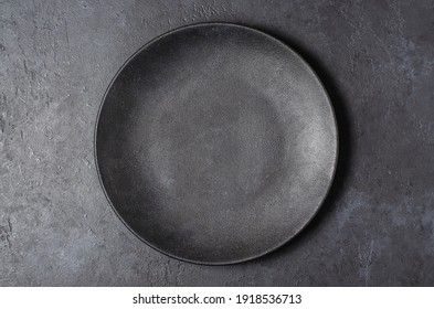 Dark grey textured concrete background for design with black food plate. Copy space - Shutterstock ID 1918536713
