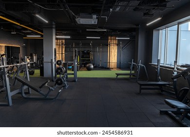 Dark gym interior with sports equipment, empty room in the morning