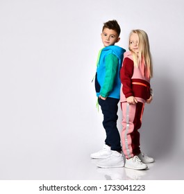 Dark haired boy and blonde girl in stylish jym suits standing back to back. Children athletes, sportswear fashion , togetherness, loving brother and sister. Portrait isolated on light grey, copy space - Shutterstock ID 1733041223