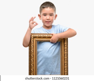 Dark Haired Little Child Holding Frame Doing Ok Sign With Fingers, Excellent Symbol