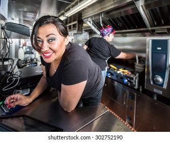 Dark Haired Smiling Cashier With Blue Eyes On Food Truck