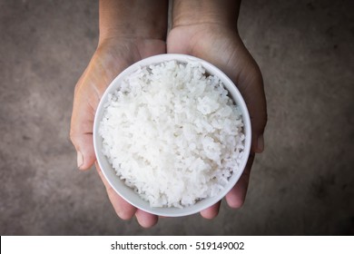 Dark Hand Holding Bowl Of Rice