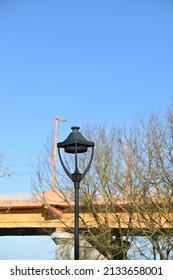 Dark High Outdoor Chandelier In The Background Of The Bridge And The Sky