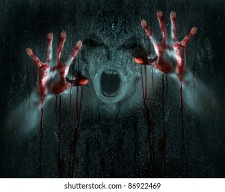 Dark Horror Scene of a Demon or Zombie with Bloody Hands against Icy Wet Glass
