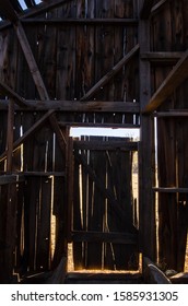 Dark Interior Of Abandoned Antique Barn Door In Silhouette