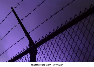 A dark iron fence, dark smoke in the background
