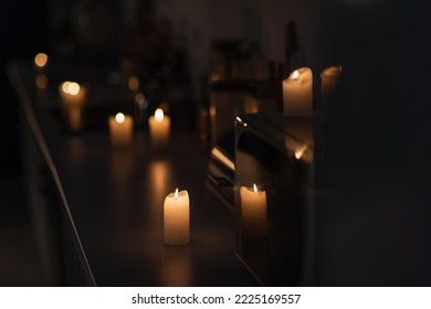 Dark Kitchen With Candles Burning On Worktop During Energy Blackout