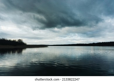 Dark lake landscape. Stormy weather scenic view. Melancholic landscape. Rainy day by the lake. Sad panoramic background.