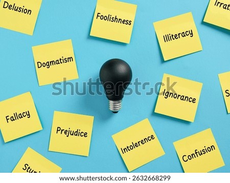 Dark light bulb is surrounded by sticky notes with negative concepts written on them, representing negativity, lack of ideas and creativity