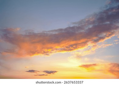 Dark and light clouds blend together in a stunning sunset sky. The sun's golden glow subtly illuminates the edges of the clouds, creating a dreamy and moody effect.