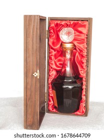 Dark Liquor In Fancy Crystal Bottle Packaged In Elegant Oak Wood Box With Red Cloth