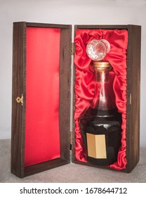 Dark Liquor In Fancy Crystal Bottle Packaged In Elegant Oak Wood Box With Red Cloth