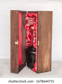 Dark Liquor In Fancy Crystal Bottle Packaged In Elegant Oak Wood Box With Red Cloth