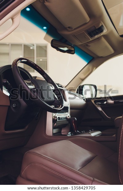 Dark luxury car Interior - steering wheel,\
shift lever and dashboard.
