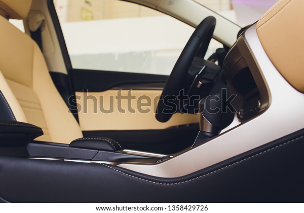 Dark luxury car Interior - steering wheel,\
shift lever and dashboard.
