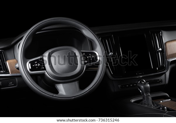 Dark luxury car Interior - steering wheel, shift\
lever and dashboard. Car interior luxury. Beige comfortable seats,\
steering wheel, dashboard, climate control, speedometer, display,\
light wood panels