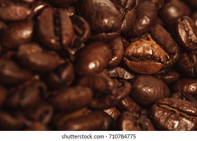 Dark many roasted coffee beans texture background.