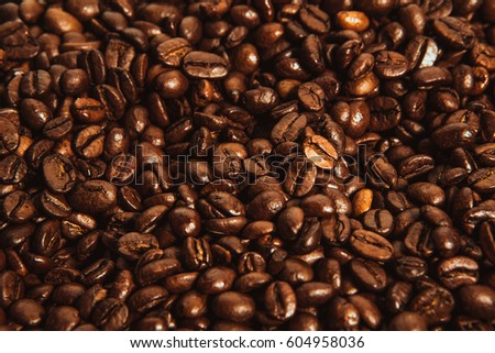 Dark many roasted coffee beans texture background.