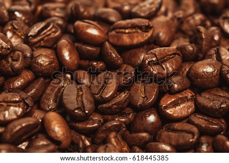 Dark many roasted coffee beans texture background.