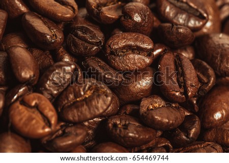 Dark many roasted coffee beans texture background.