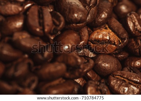 Dark many roasted coffee beans texture background.