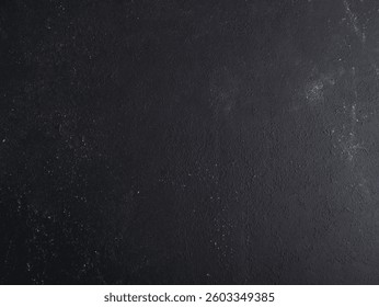 Dark matte black wall surface with subtle texture and scattered white specks, ideal for grunge-themed designs, modern layouts, product mockups, or minimalist creative backgrounds