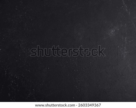 Dark matte black wall surface with subtle texture and scattered white specks, ideal for grunge-themed designs, modern layouts, product mockups, or minimalist creative backgrounds