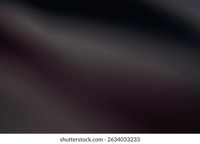 a dark, metallic surface with a subtle gradient, suggestive of a black chrome finish. Light reflects across the surface, creating streaks of lighter gray and hints of a deep