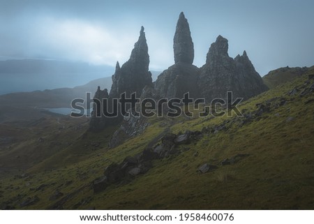 Dark, moody, ominous landscape at the dramatic and iconic rock pinnacle Old Man of Storr on the Isle of Skye, Scotland.