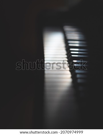 dark moody piano with artistic lighting part shadow black and white keys