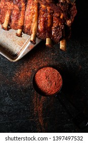 Dark And Moody Rack Of Meaty Baby Back Ribs With Spicy Dry Rib Rub Seasoning On A Worn Metal Sheet Pan