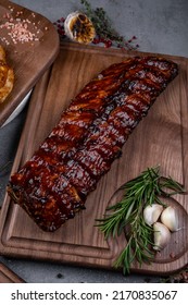 Dark And Moody Rack Of Meaty Baby Back Ribs With Spicy Dry Rib Rub Seasoning On A Worn Metal Sheet Pan