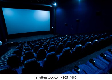 Dark movie theatre interior. screen, chairs
