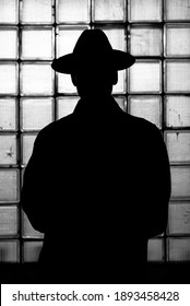 dark mystical silhouette of a man in a hat at night in retro Noir style