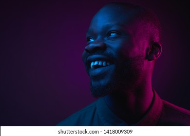 Dark Neon Portrait Of Young Man With Beard, Wearer In Shirt. Pink And Blue Light. Technology