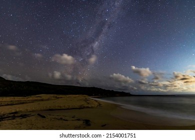In the dark of the night at the beach under the Milky Way sky and stars at Putty Beach on the Central Coast of NSW, Australia.