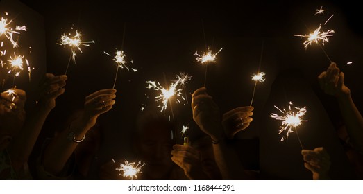 dark night celebrate concept with lot of hands taking and using light sparkles fire together. have fun for new year eve or party. companionship and friendship during celebration. happy lifestyle - Powered by Shutterstock