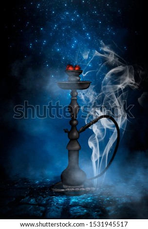 Dark night magic scene. Eastern hookah with smoke on the old cobblestone road. Blue neon, moonlight at night.