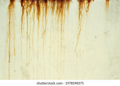 Dark orange streaks on a pale yellow plaster wall - Shutterstock ID 1978598375