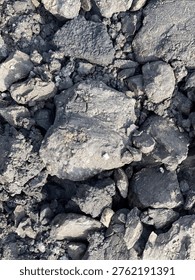 Dark overburden material with rough texture commonly found in mining and industrial excavation areas.