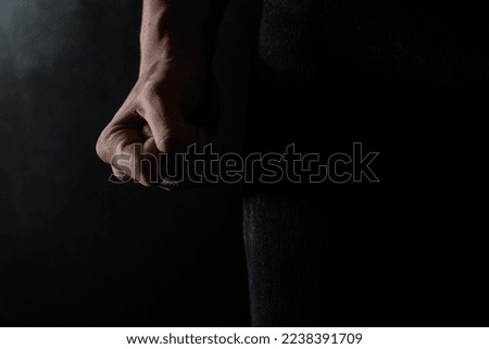 dark photo showing man's fist. Concept showing aggression and domestic violence