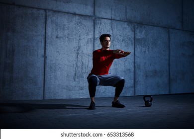 Dark picture of athlete doing squats