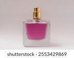 Dark pink colonge with gold atomizer, on the white background. Pink perfume with gold detail, isolated on the white background