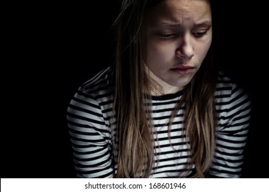Dark portrait of a depressed teen girl, studio shot