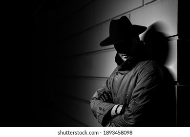 Dark Portrait Of A Man In A Raincoat With A Hat At Night On The Street In A Crime Noir Style