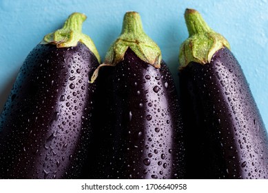 Dark purple eggplants sprinkled with water. 3 eggplants close-up above view. Freshly harvested vegetables covered with drops of water. - Powered by Shutterstock