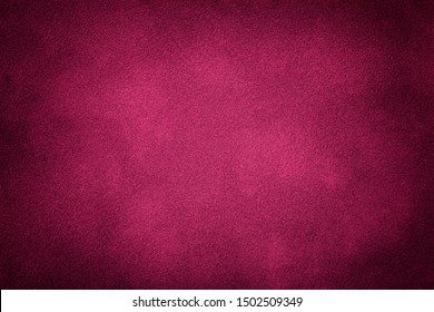 Dark purple matte background of suede fabric, closeup. Velvet texture of seamless wine leather. Felt material macro with vignette. Stock Photo
