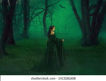 dark queen of otherworldly forces leads into realm of dead souls. bloody vampire in long velvet emerald dress lures into her lair, pretty princess lost her way and follows bat, mystic photo from back